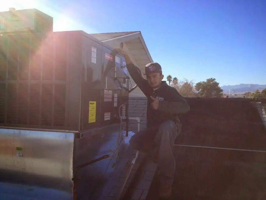 HVAC technician performing AC Tune-Up on a rooftop unit in Cleveland